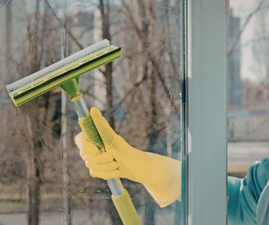 Image of someone squeegeeing a dirty window